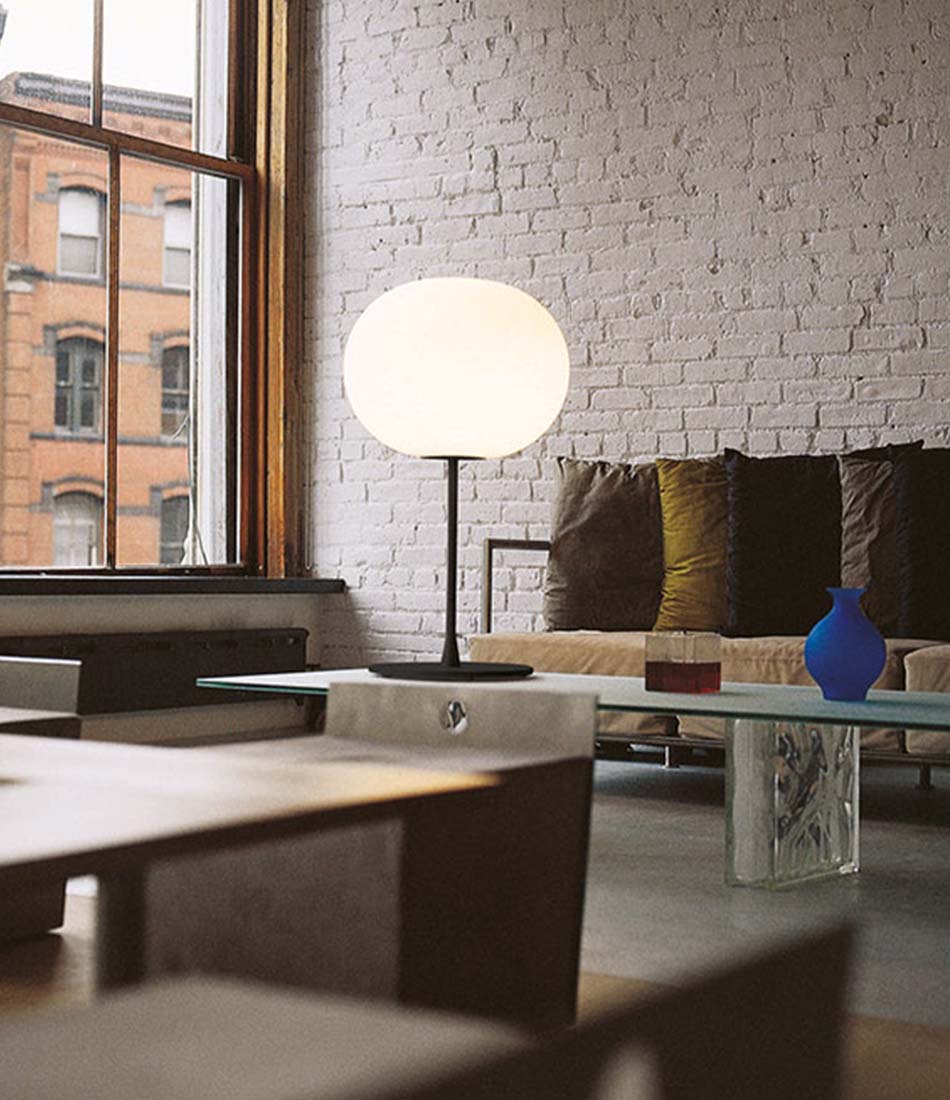 Flos Glo-Ball table lamp on a coffee table in a furnished living room.