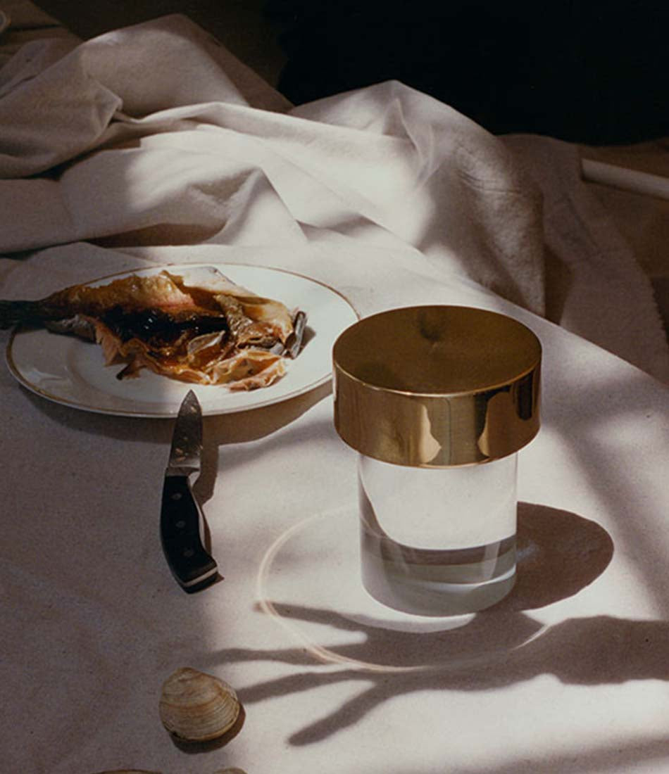 Flos Last Order table lamp beside a dinner plate on a table cloth.