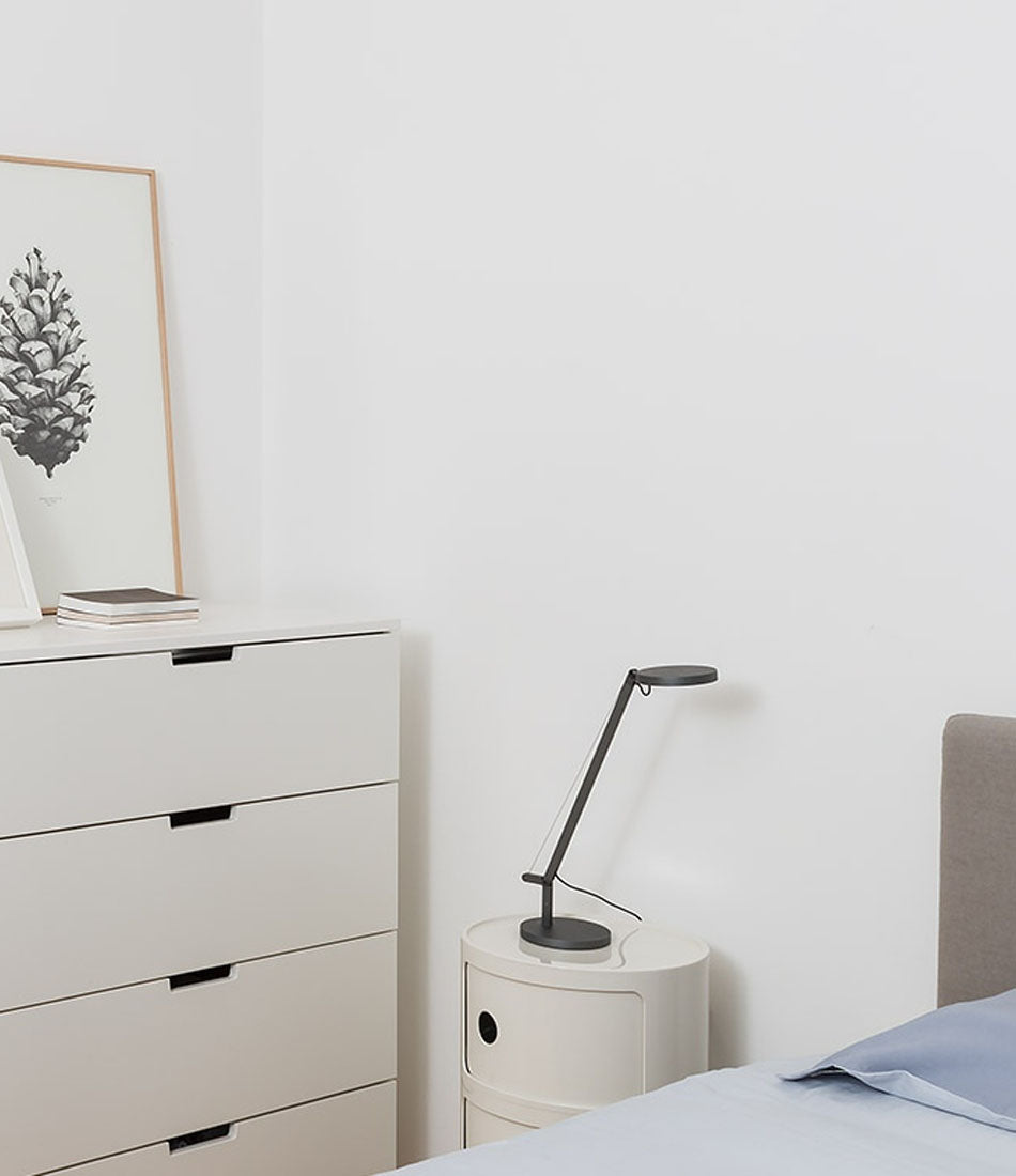 Artemide Demetra micro table lamp on a bedside table in a bedroom.