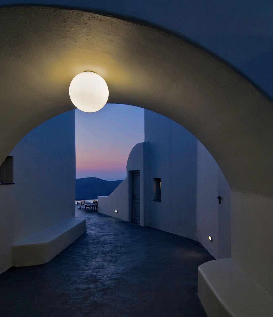 Artemide Dioscuri wall/ceiling lamp mounted under a concrete arch above a walkway.