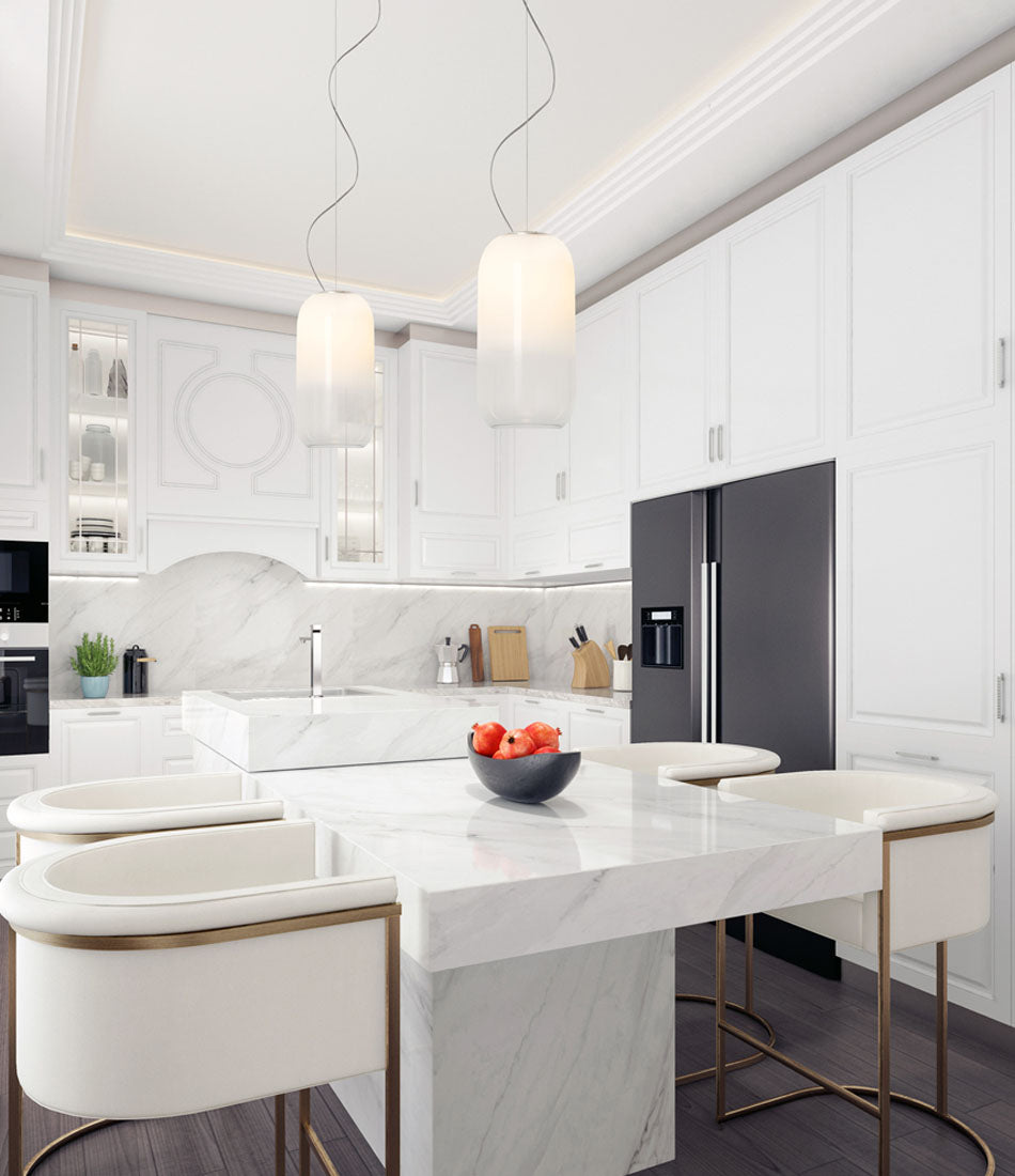 Two white Artemide Gople Suspension lamps above a marble island in a kitchen.