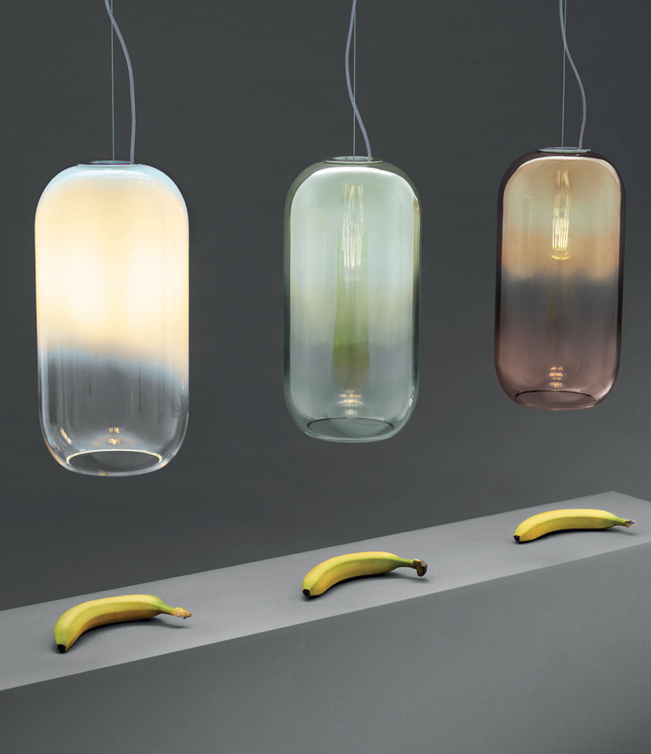 Three Artemide Gople Suspension lights above three bananas on a ledge.