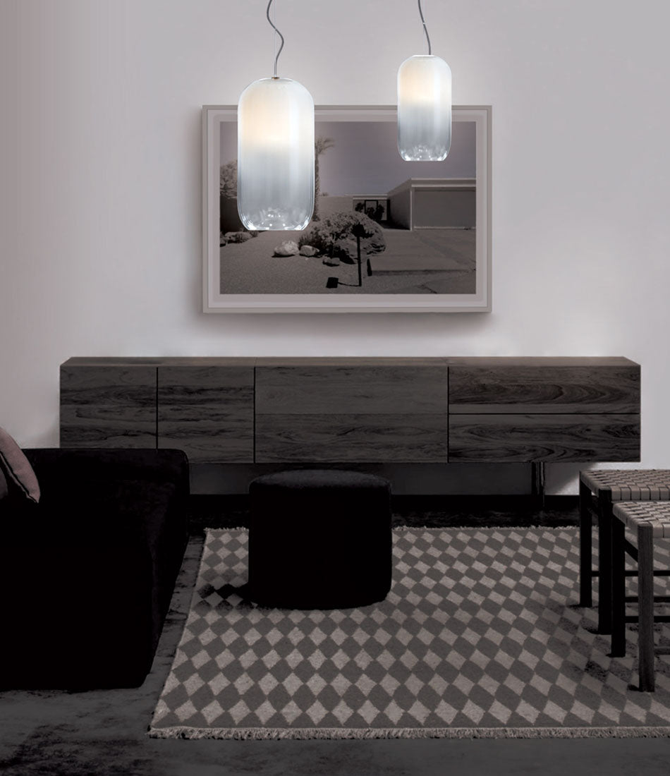 Two white Artemide Gople suspension light hanging above a living room.