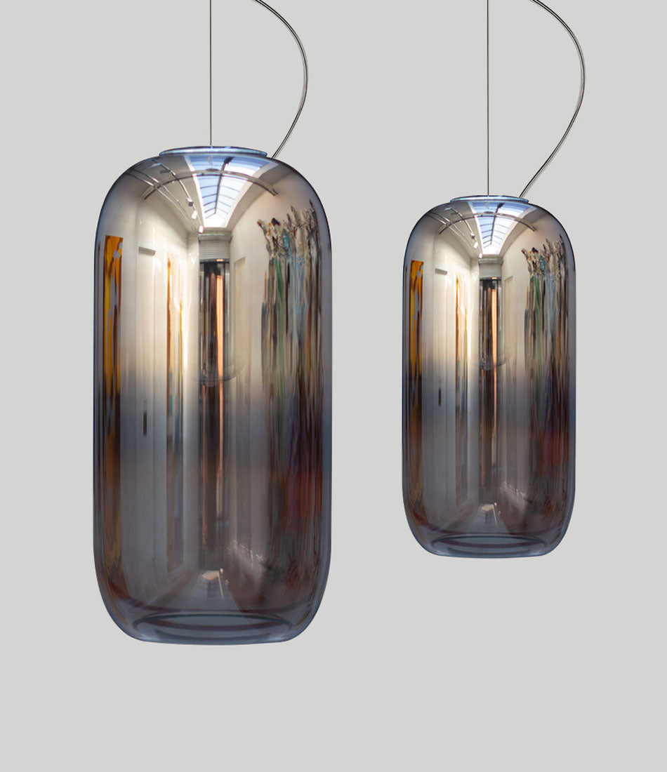 Two silver Artemide Gople suspension lights side by side.