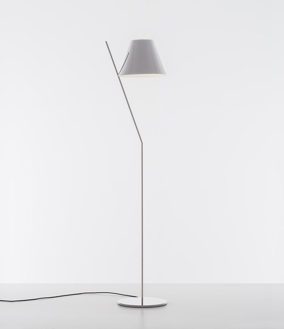 White Artemide la Petite floor lamp with tilted stem and conical shade.