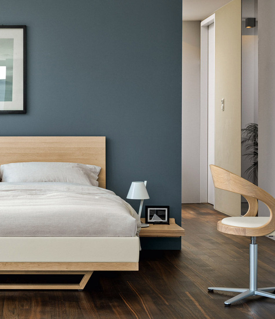 Artemide La Petite table lamp on a bedside table in a bedroom.