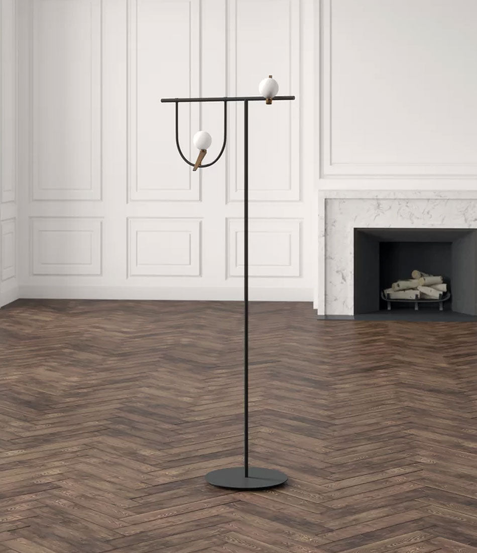 Artemide Yanzi floor lamp in an empty room, with fireplace and wood floor.