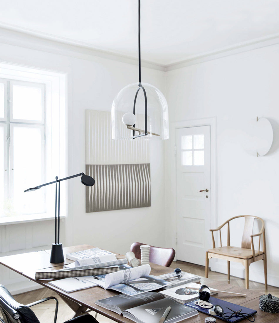 Artemide Yanzi suspension lamp over cluttered office desk.