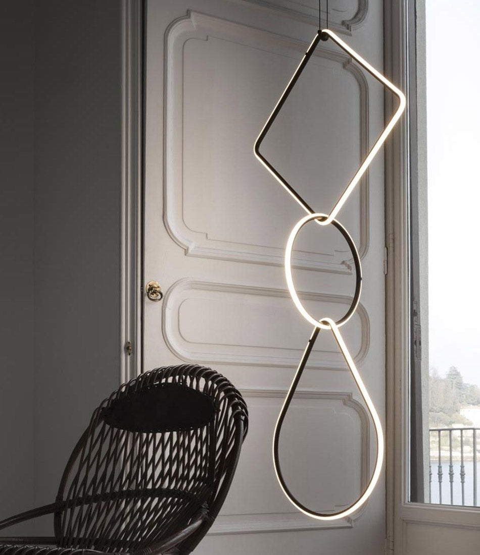 Flos Arrangements Pendant Light 5 hangs in front of open doorway next to woven lounge chair.