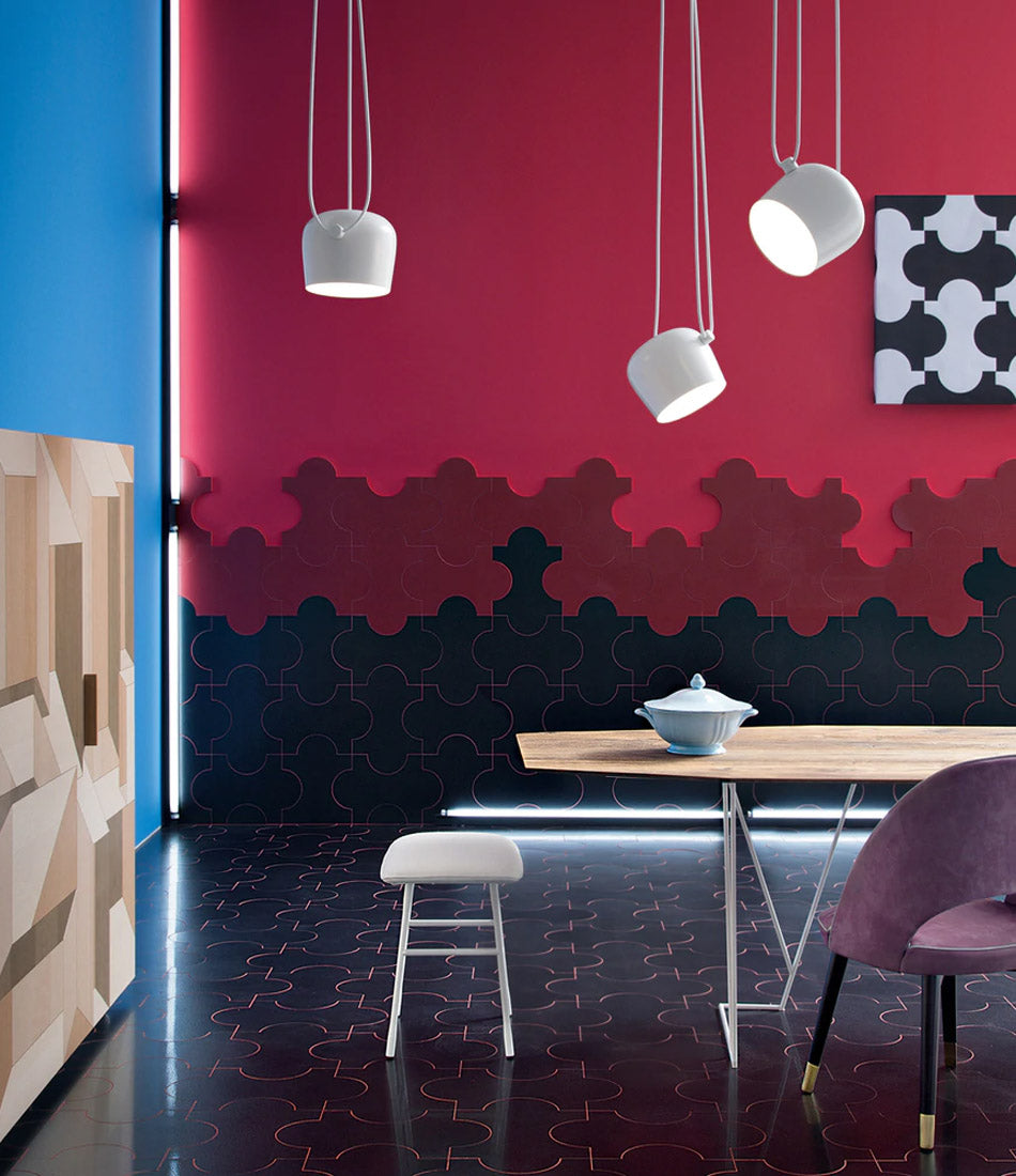 Three small white Flos AIM Pendant lamps suspended over a wooden dining table in an ornate dining room.