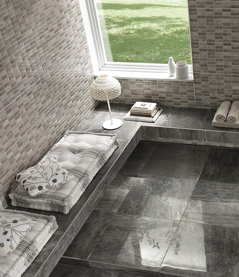 Flos Tatou table lamp on a seating ledge next to pillows and books.