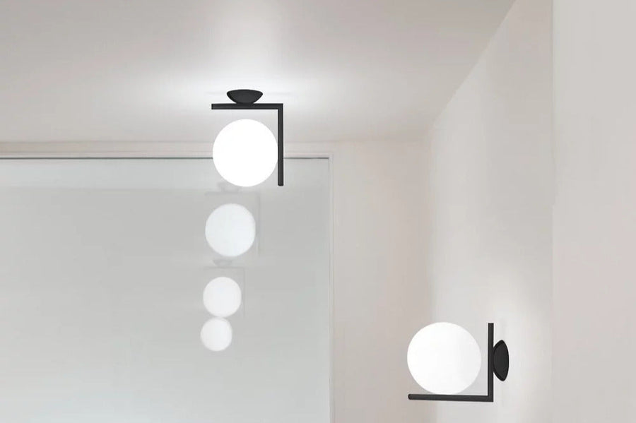 Flos IC Lights Ceiling/Wall Sconce mounted to wall next to wood molding.