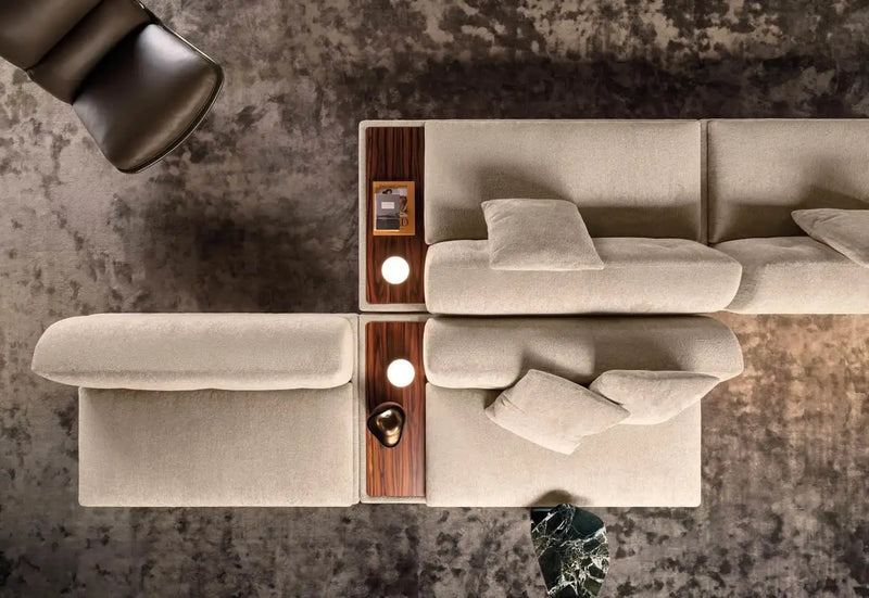 Top-down view of the Minotti Supermoon sofa with a wooden accent coffee table on a textured carpet.