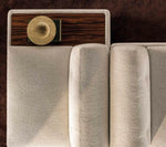 Minotti Supermoon sofa with a wooden side table and decorative item on a dark brown background