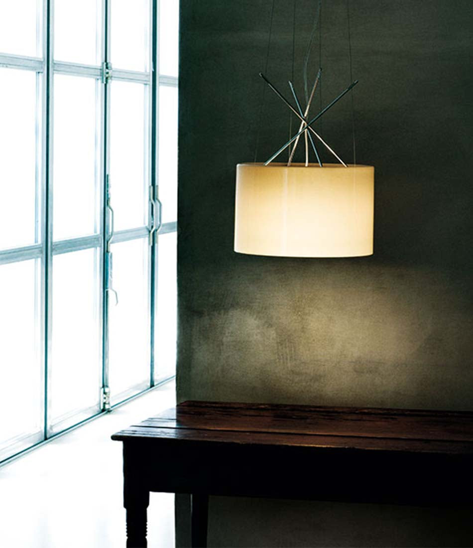 Flos Ray suspension lamp hanging above a wooden table.