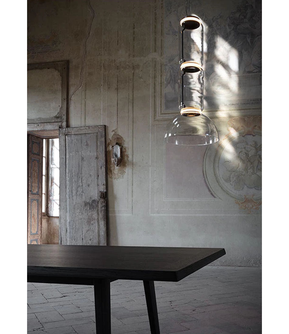Flos Noctambule suspension lamp hanging in a room with venetian plaster and vintage decor.