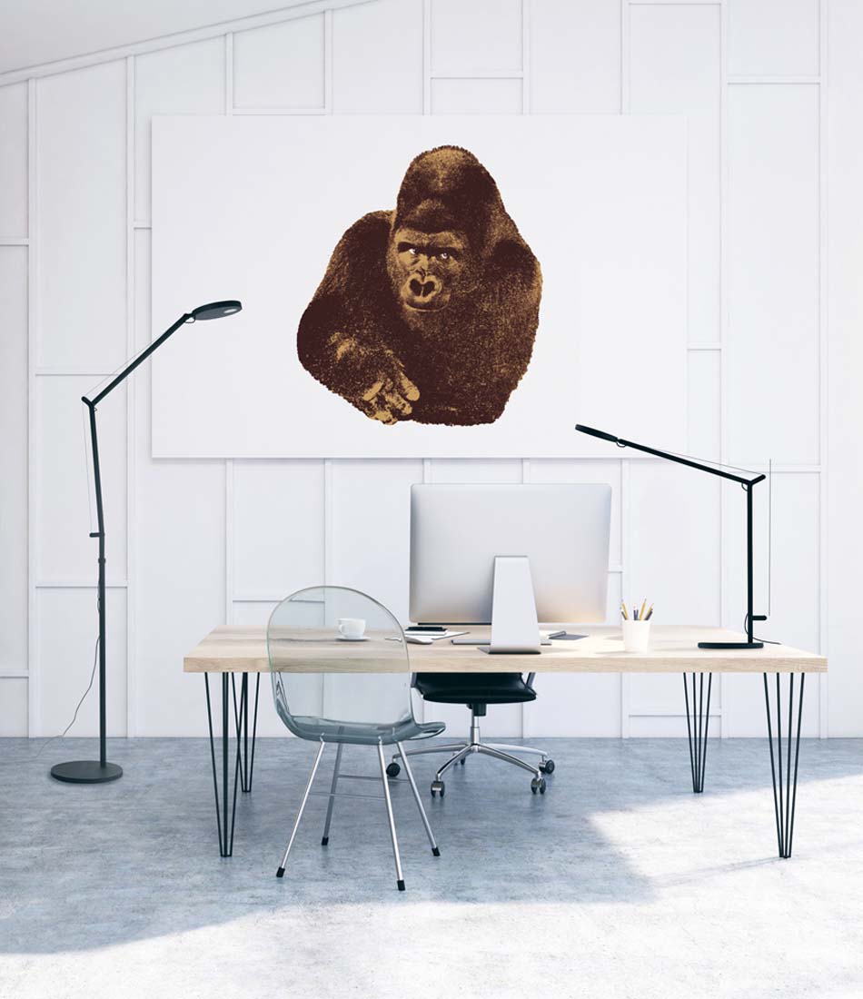 Artemide Demetra floor lamp and table lamp on an office desk beneath a gorilla picture.