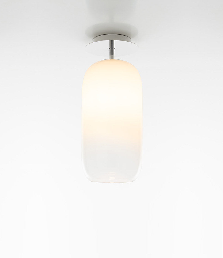 Pill-shaped Artemide Gople ceiling lamp, with blown glass diffuser in gradient white.