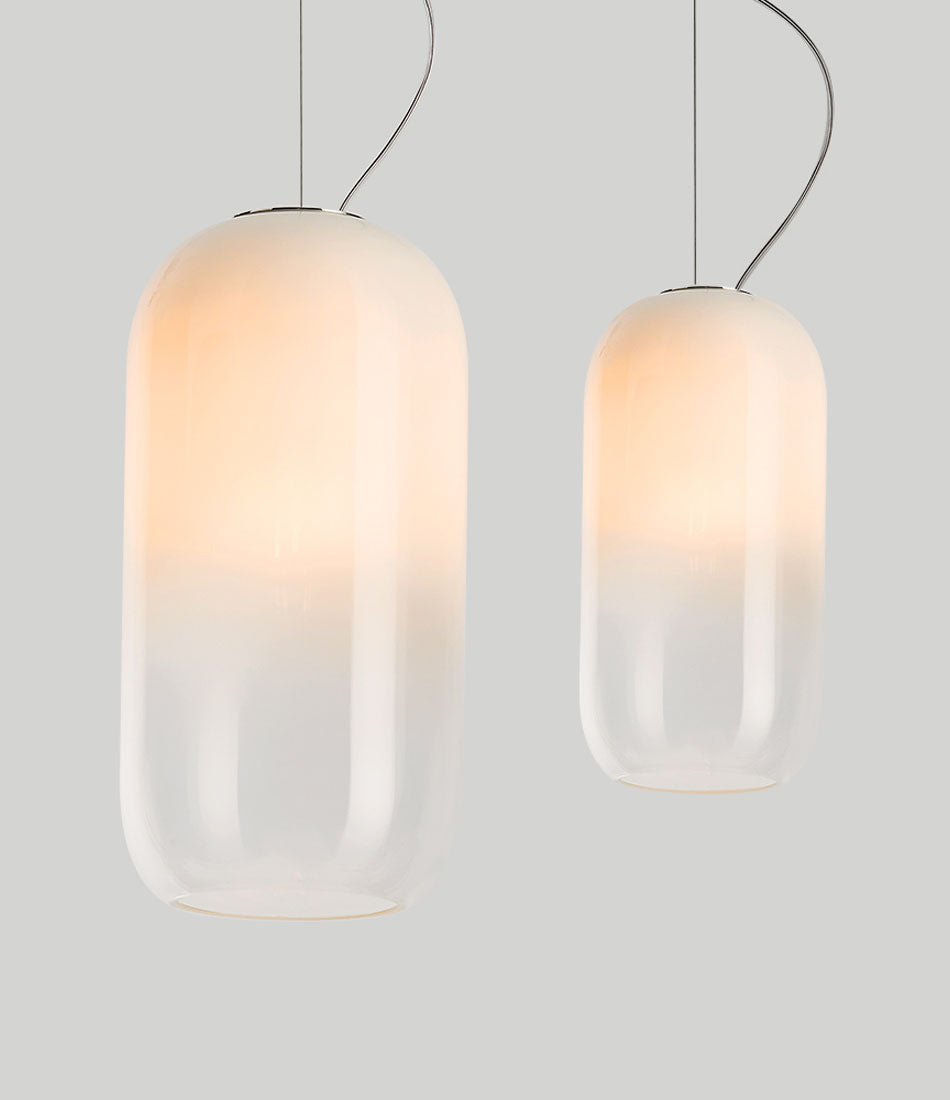 Two white Artemide Gople suspension lamps hanging side by side.