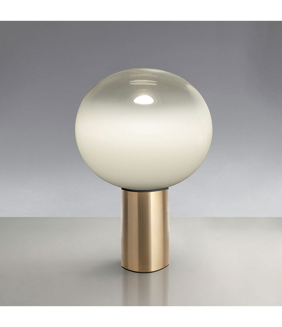 Artemide Laguna table lamp, with spherical white blown glass diffuser atop a cylindrical satin brass base.