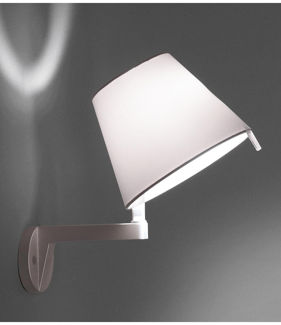 Artemide Melampo Mini wall lamp mounted to a wall, with shade in tilted position.
