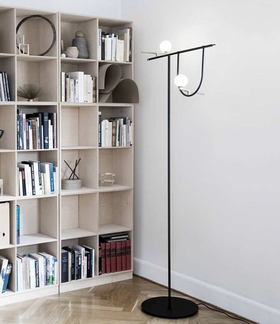 Artemide Yanzi floor lamp in front of a bookshelf.