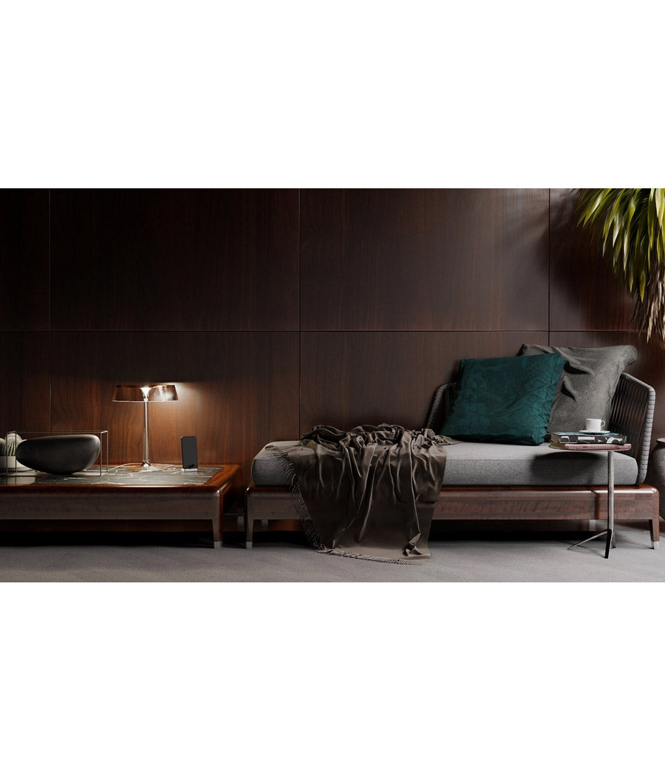 Flos Bon Jour table lamp on a low coffee table next to a chaise lounge.