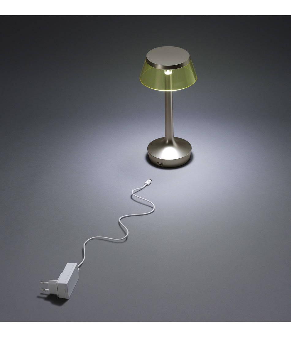 Flos Bon Jour Unplugged table lamp, with charging cable laying next to it.