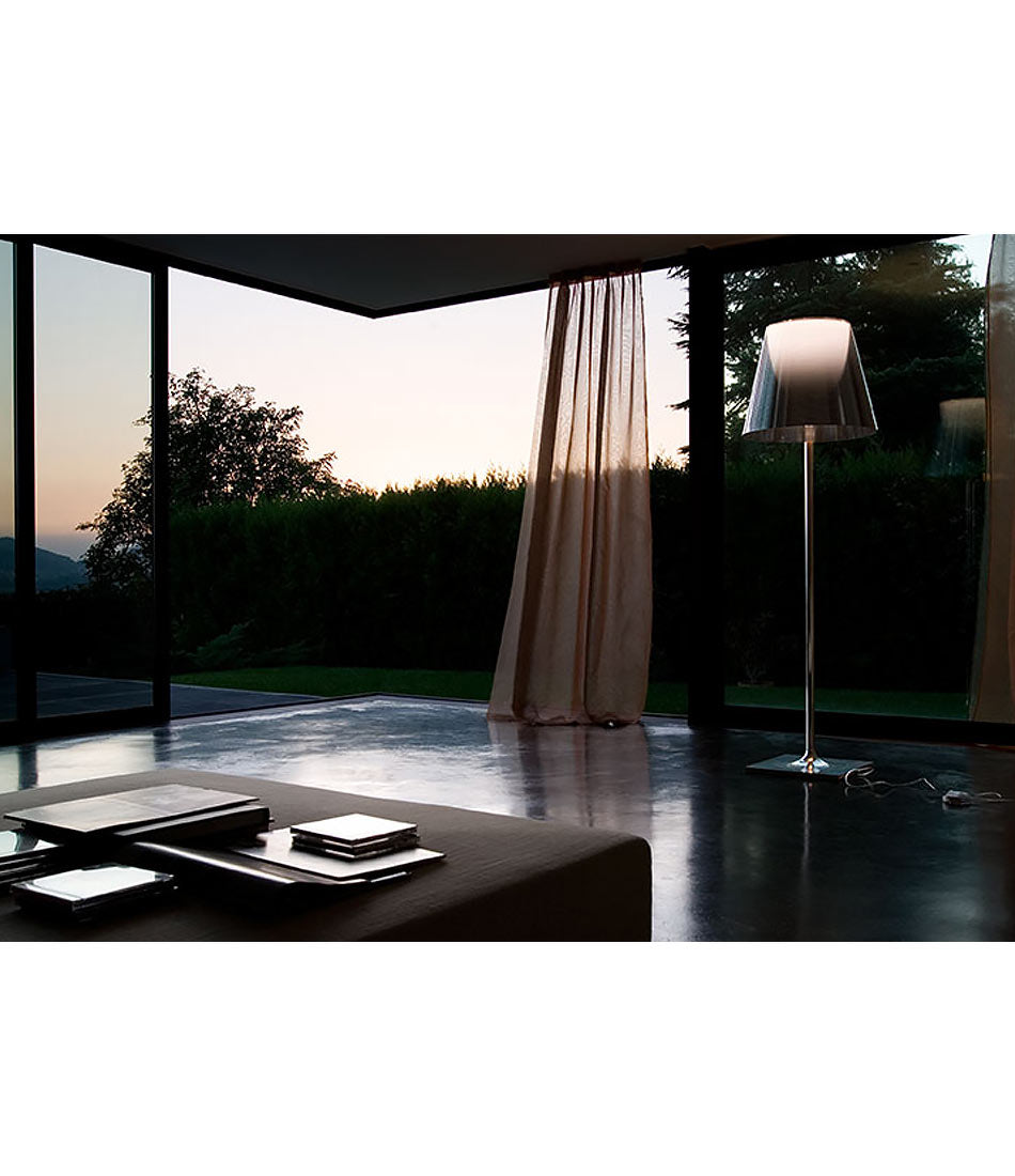 Flos KTribe floor lamp in front of an open patio door in a modern home.