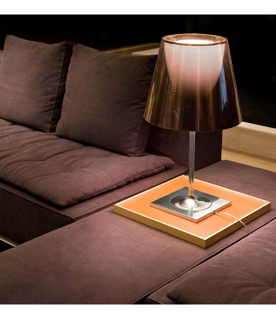 Flos KTribe table lamp on a corner table on a sectional sofa.